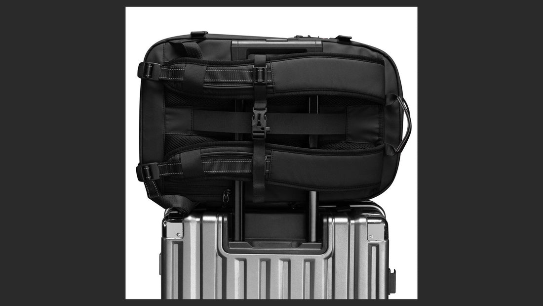 Airbag Lite carry-on backpack resting on a wheeled suitcase