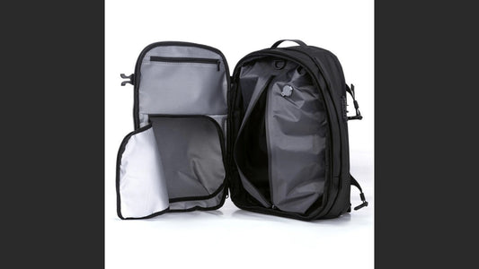 Airbag Lite travel backpack opened flat showing packing compartments and pockets