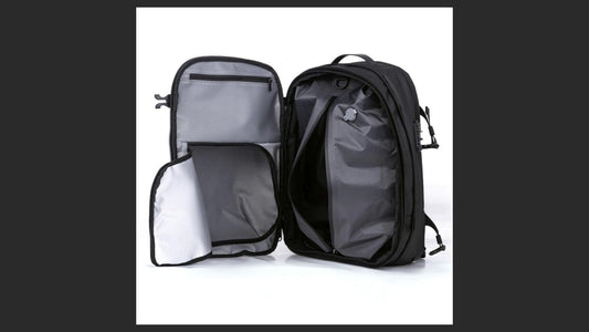 Airbag Lite travel backpack opened flat showing the main packing and vacuum compression compartments